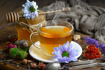 Sweet, hot tea with dry tea leaves, on an old background.