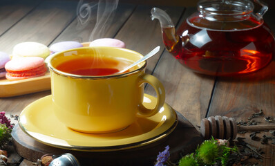 Sweet, hot tea with dry tea leaves, on an old background.