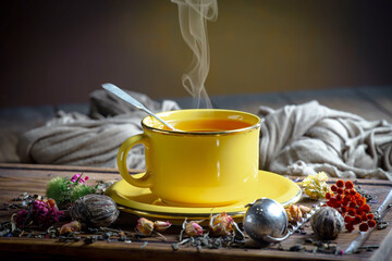 Sweet, hot tea with dry tea leaves, on an old background.