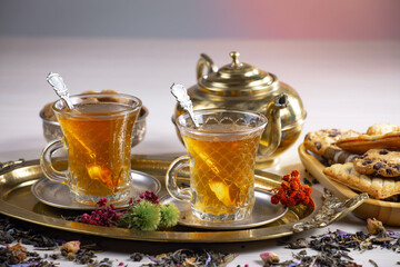 Sweet, hot tea with dry tea leaves, on an old background.