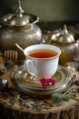 Sweet, hot tea with dry tea leaves, on an old background.