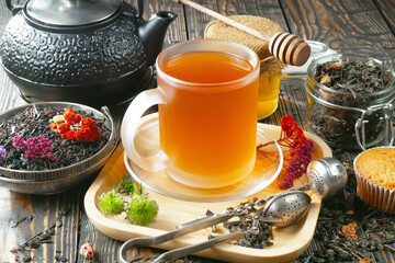 Sweet, hot tea with dry tea leaves, on an old background.