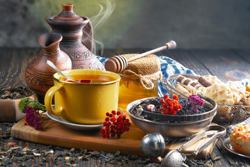 Sweet, hot tea with dry tea leaves, on an old background.