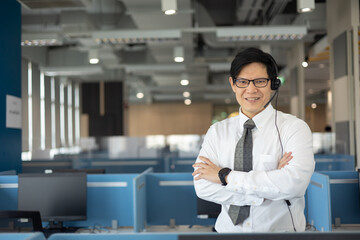 Portrait of smart asian male customer service representative with headset, smile face and stand at call center room. - obrazy, fototapety, plakaty