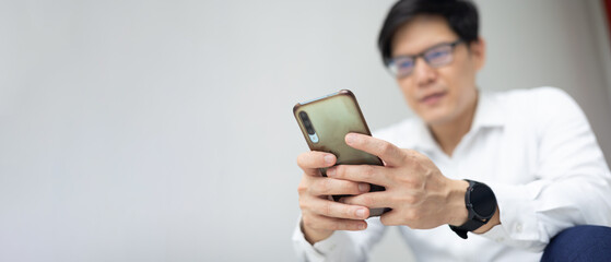 Asian office worker hold mobile phone in hand chat complaint to customer service.