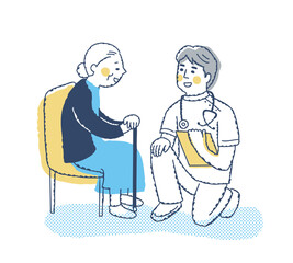 シニア女性としゃがんで話す医療従事者