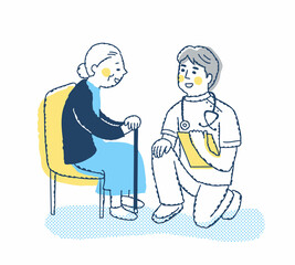 シニア女性としゃがんで話す医療従事者