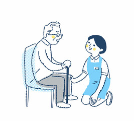 シニア男性としゃがんで話す介護スタッフ