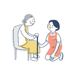 シニア女性としゃがんで話す介護スタッフ