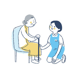 シニア女性としゃがんで話す介護スタッフ