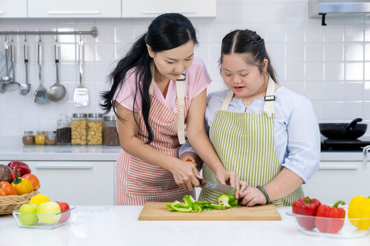 Happy Asian mother and daughter in kitchen