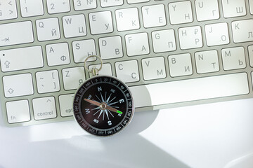 The compass lies on the computer keyboard