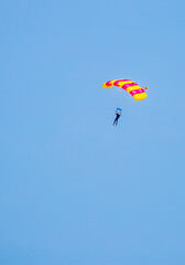 Skydiving. Flying parachutists against the background of the blue sky and mountains. Extreme sport and entertainment.