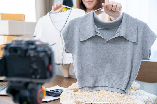 Online selling clothes concept, Women show clothing fashion while selling LIVE broadcast.