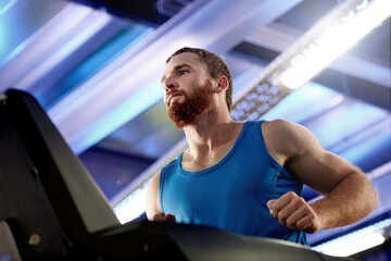 Gym time is quality time. a young man working out on a treadmill at the gym.