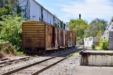 Railroad siding with goods wagons waiting. Nashville TN, September 2019. Railway tracks and white buildings. 