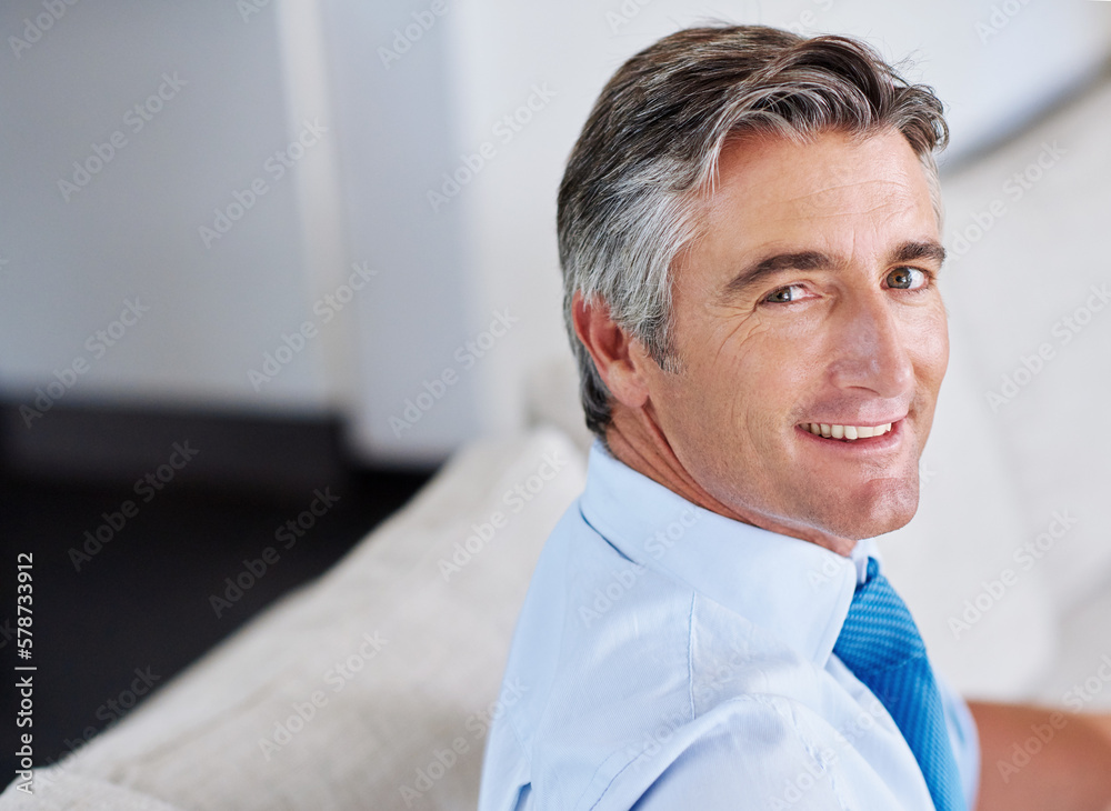 Poster Hes a self-made man. Portrait of a mature businessman sitting on a sofa.