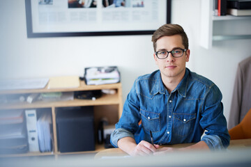 His career is on track. Portrait of a young male designer at his desk.