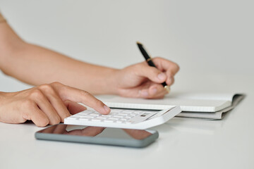 Fototapeta premium Hands of businessman making calculations and taking notes in planner