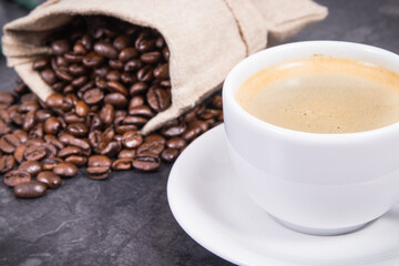 Coffee in cup and roasted dark coffee beans in bag