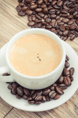 Coffee in white cup and roasted dark coffee beans