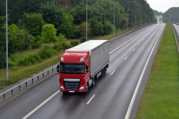 Red truck on highway - business, commercial, cargo transportation concept.