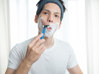 髭剃りをする男性