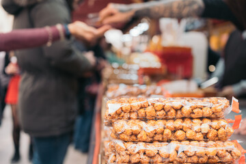 Close-up image of a stack of bags of sugared hazelnuts at a Spanish medieval market street stall.