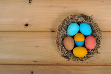 Easter eggs, painted in the national colors of the Ukrainian flag in a nest on a background of wooden boards.