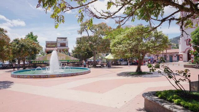 Guatap&eacute; town and nice colonial park with water fountain, trees and colorful houses in Colombia in South America in the Andes mountains.
