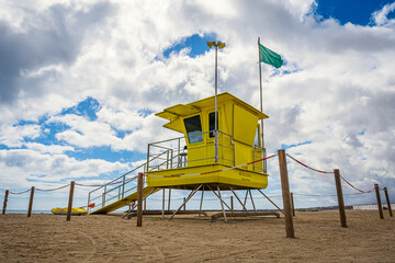 Eine gelbe Lifeguard-Station am Strand von Puerto del Rosario auf Fuerteventura mit grüner Flagge