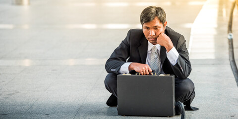 business man in suit frustrated he sad for lost work job sit on street upset fail unhappy after...