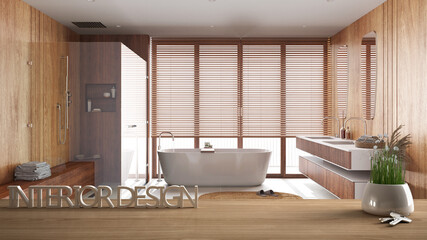 Wooden table, desk or shelf with potted grass plant, house keys and 3D letters making the words interior design, over wooden bathroom, project concept copy space background
