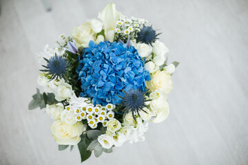 A wedding bouquet of white flowers of chamomile, roses, hydrangea, eucalyptus stands in a vase. Wedding concept