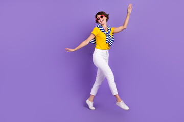 Fototapeta na wymiar Full length photo of adorable cheerful lady wear comfort clothes enjoy free time go street empty space isolated on purple color background