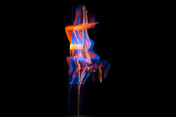 Gymnastic tricks. Young girl performing pole dance isolated over black studio background with mixed neon lights. Concept of sport and dance, beauty of movements, action, modern style