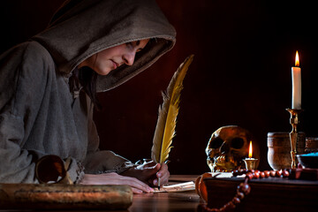 Medieval witch writes letter with quill pen