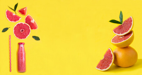 Grapefruit smoothie in a glass bottle and  pyramid of grapefruit in balance on the yellow background. Close-up. Copy space.