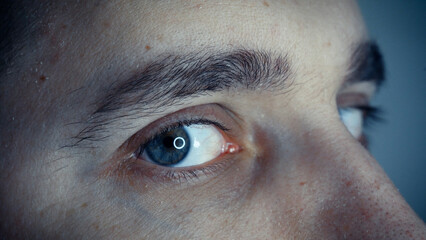 Close-up of blinking green eyes. A young man opens and closes his beautiful eye.