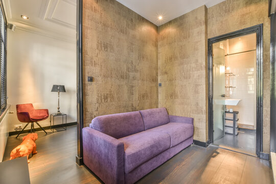 Purple comfortable sofa in modern illuminated apartment