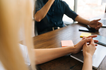 Close-up cropped shot of unrecognizable female and male businesspeople discussing deal, signing contract sitting at table. Negotiation appointment in boardroom. Take part in talk concept