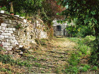 Stone sidewalk up a hill in an old greek village in the summer