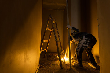Construction worker wearing worker overall with wall plastering tools renovating apartment house....