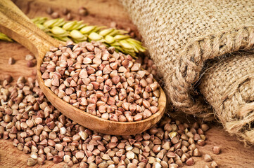 Ripe organic buckwheat grains in wooden spoon