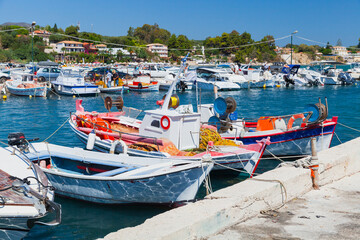 Fototapeta na wymiar Small fishing boats are moored in port of Agios Sostis village. Zakynthos