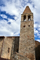 Fototapeta na wymiar Historic church with a stone bell tower in the town of Magliano in Toscana