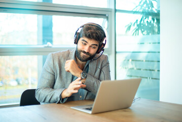 Multi-ethnic business man wearing formal clothes and headset explaining something to client during online video call on laptop.