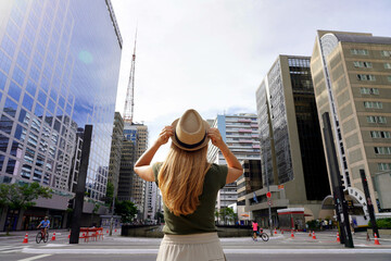 Beautiful girl arrives in the big city of Sao Paulo. Young woman with hat on Paulista Avenue in Sao...