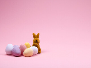 bunter Ostereier mit Osterhase vor rosa Hintergrund