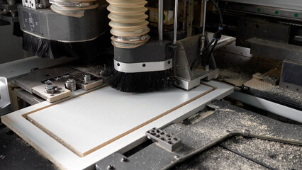 Close-up. A CNC machine cuts a piece of wood with a cutter. A modern machine cuts a pattern in furniture production. The machine cuts a piece of wood.